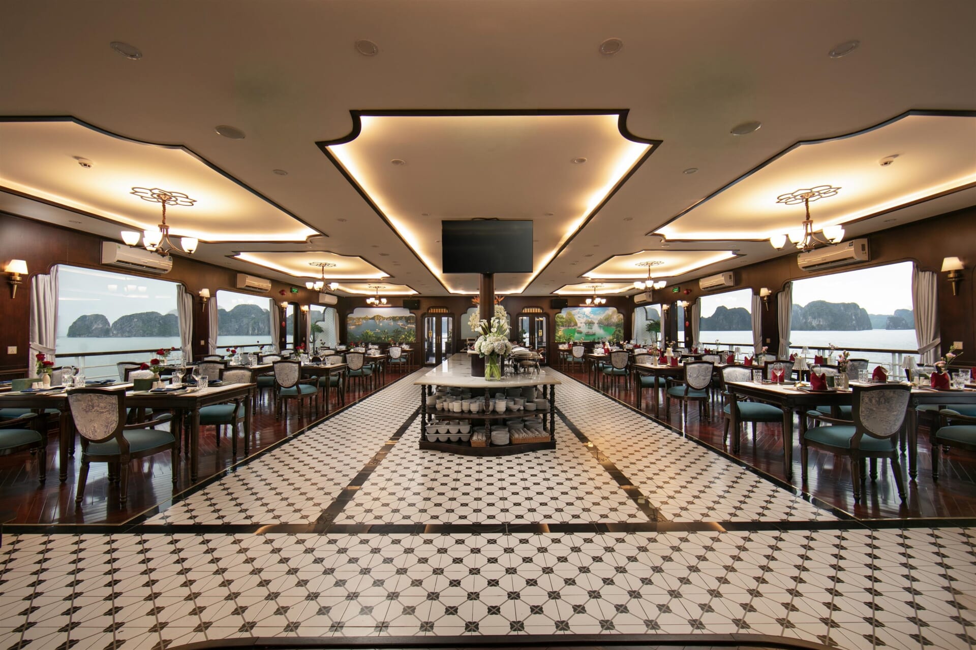 Dining room of Hermes Premium with set tables and windows onto Halong Bay